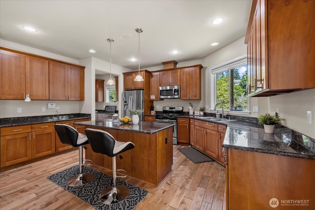 2025 NE 37th Pl, Renton, WA 98056 - kitchen featuring appliances with stainless steel finishes, brown cabinets, a center island, light wood-type flooring, and a breakfast bar