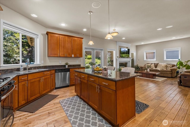 2025 NE 37th Pl, Renton, WA 98056 - kitchen featuring dishwasher, brown cabinets, a center island, light wood-style flooring, and a fireplace