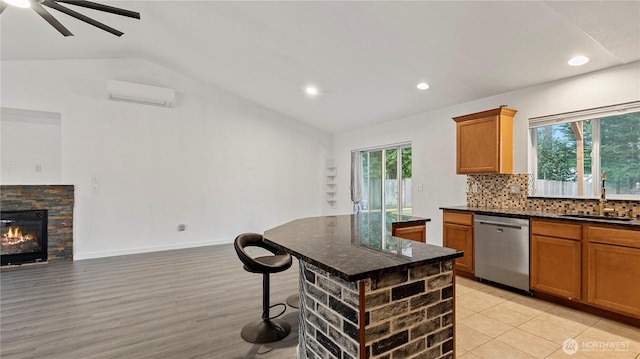 215 19th St, Gold Bar, WA 98251 - kitchen featuring dishwasher, a sink, vaulted ceiling, a wall mounted air conditioner, and decorative backsplash