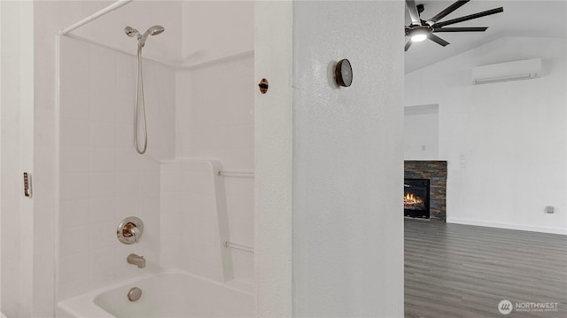 215 19th St, Gold Bar, WA 98251 - bathroom with a ceiling fan, a wall mounted AC, washtub / shower combination, baseboards, and a stone fireplace