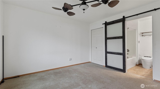 215 19th St, Gold Bar, WA 98251 - unfurnished bedroom featuring carpet floors, a barn door, baseboards, and ensuite bathroom