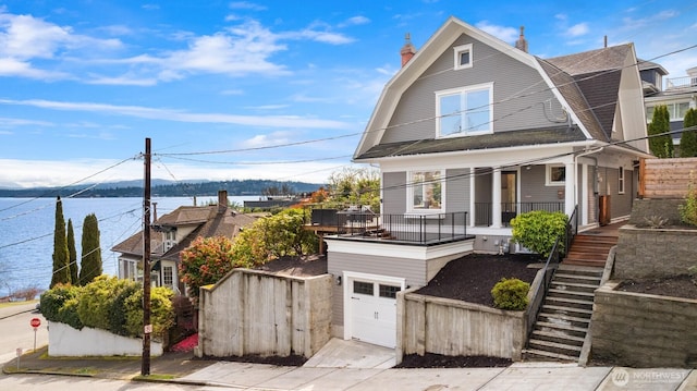 3807 E Jefferson St, Seattle, WA 98122 - dutch colonial featuring a gambrel roof, covered porch, roof with shingles, a chimney, and stairway