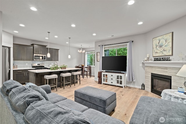 1116 NE 14th Way, Battle Ground, WA 98604 - living area featuring recessed lighting, light wood-style floors, a fireplace, baseboards, and a chandelier
