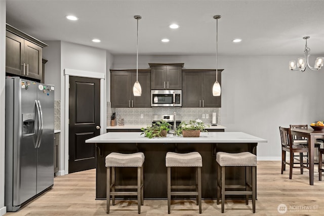 1116 NE 14th Way, Battle Ground, WA 98604 - kitchen featuring stainless steel appliances, light countertops, dark brown cabinets, decorative backsplash, and recessed lighting