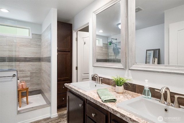 477 SE Old Arcadia Rd, Shelton, WA 98584 - bathroom with tiled shower, double vanity, and wood finished floors