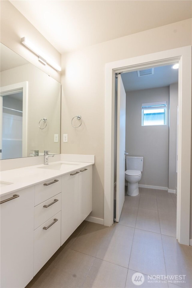 33488 Golden Lakes Ln SE, Black Diamond, WA 98010 - full bathroom with double vanity, toilet, baseboards, and tile patterned floors