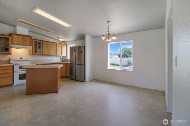 524 New Gate Dr, Prosser, WA 99350 - kitchen featuring double oven range, freestanding refrigerator, under cabinet range hood, light countertops, and a chandelier