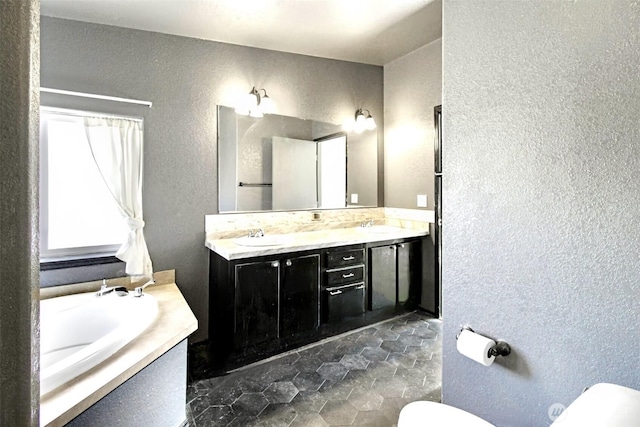 524 New Gate Dr, Prosser, WA 99350 - bathroom featuring a textured wall, toilet, double vanity, and a tub