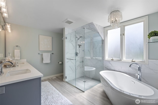 20520 NE 35th Pl, Sammamish, WA 98074 - full bath with a marble finish shower, a soaking tub, double vanity, a chandelier, and wood finished floors