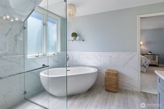 20520 NE 35th Pl, Sammamish, WA 98074 - ensuite bathroom with tile walls, a freestanding tub, vanity, and a wainscoted wall
