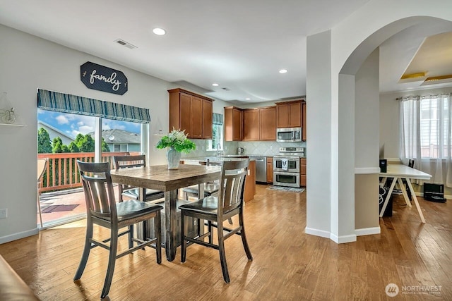 6715 Quincy Ave SE, Auburn, WA 98092 - dining space with arched walkways, light wood-style floors, recessed lighting, and baseboards