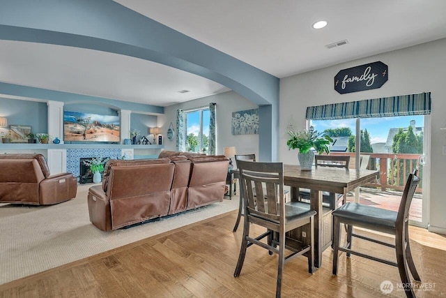 6715 Quincy Ave SE, Auburn, WA 98092 - dining area featuring wood finished floors, arched walkways, a fireplace, and recessed lighting
