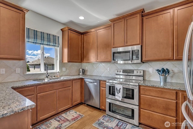 6715 Quincy Ave SE, Auburn, WA 98092 - kitchen with appliances with stainless steel finishes, a sink, light stone counters, decorative backsplash, and recessed lighting