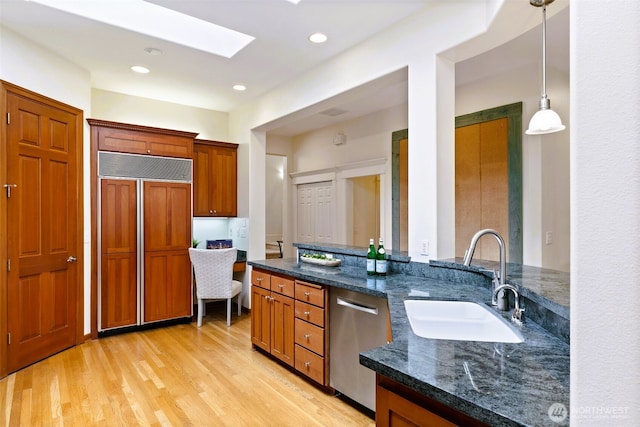 2728 206th Ter NE, Sammamish, WA 98074 - kitchen featuring paneled refrigerator, stainless steel dishwasher, dark stone counters, a skylight, and brown cabinetry