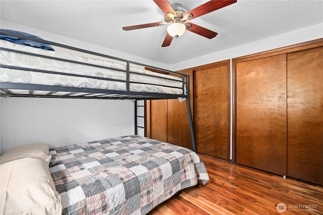 3318 18th Ave SE, Olympia, WA 98501 - bedroom featuring wood finished floors, multiple closets, a textured ceiling, and a ceiling fan
