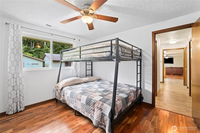 3318 18th Ave SE, Olympia, WA 98501 - bedroom with wood-type flooring, a textured ceiling, baseboards, and a ceiling fan