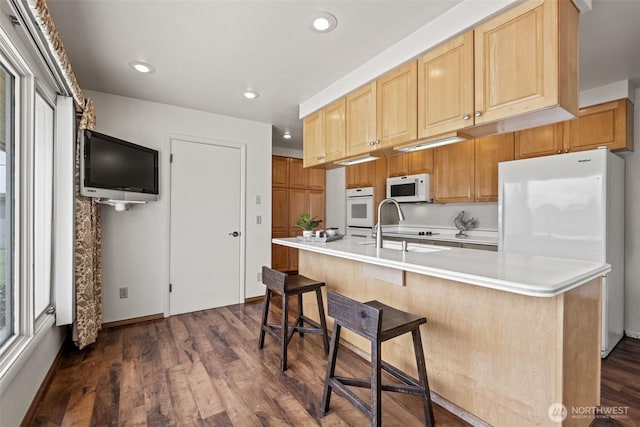 742 I St SW, Quincy, WA 98848 - kitchen featuring white appliances, light countertops, dark wood-type flooring, a sink, and a kitchen island with sink