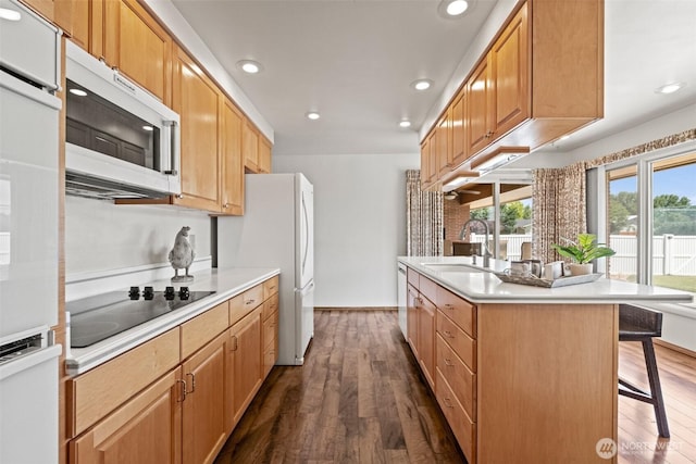 742 I St SW, Quincy, WA 98848 - kitchen featuring white appliances, a sink, a kitchen bar, recessed lighting, and dark wood-style floors