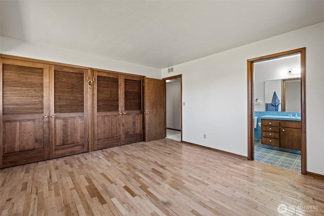 742 I St SW, Quincy, WA 98848 - unfurnished bedroom with light wood finished floors, baseboards, a sink, and connected bathroom