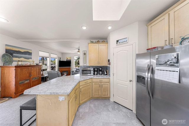 8412 Richard Way, Blaine, WA 98230 - kitchen with stainless steel fridge with ice dispenser, a peninsula, light countertops, light brown cabinets, and a ceiling fan
