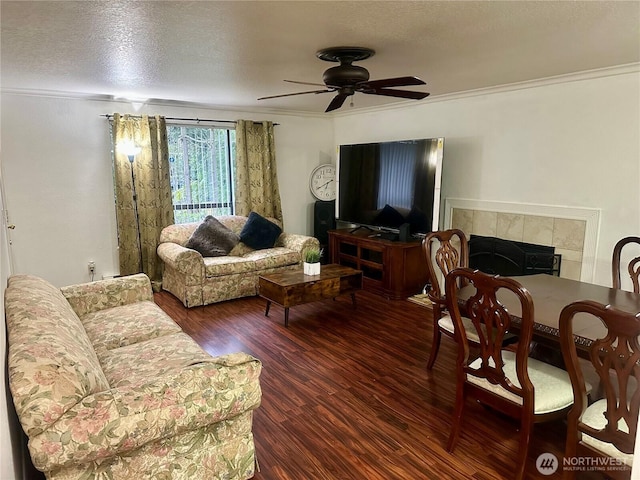14917 32nd Pl S Unit 42, Seatac, WA 98168 - living room featuring wood finished floors, ceiling fan, crown molding, a tiled fireplace, and a textured ceiling