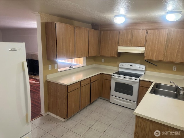 14917 32nd Pl S Unit 42, Seatac, WA 98168 - kitchen featuring white appliances, under cabinet range hood, a sink, light tile patterned flooring, and light countertops