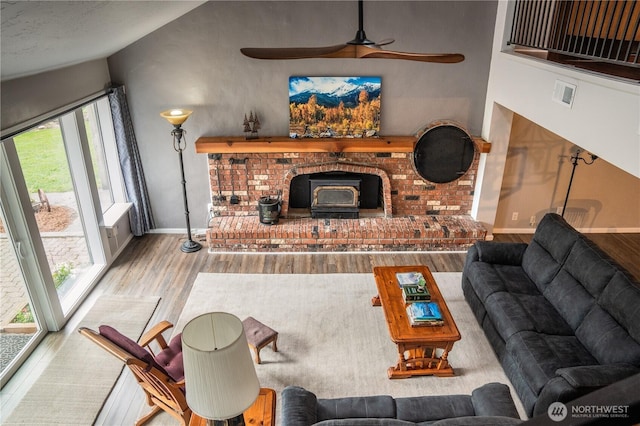 5363 Reese Hill Rd, Sumas, WA 98295 - living area featuring wood finished floors, a ceiling fan, baseboards, vaulted ceiling, and a wood stove