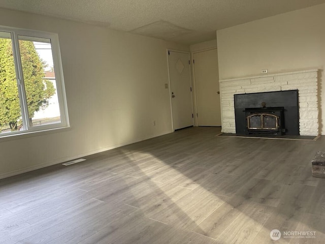 27 SW 102nd St, Seattle, WA 98146 - unfurnished living room featuring a textured ceiling, wood finished floors, and baseboards
