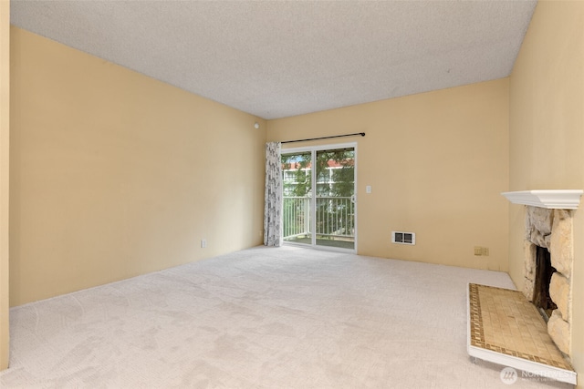 5814 200th St SW Unit D, Lynnwood, WA 98036 - unfurnished living room featuring carpet floors, a fireplace, and a textured ceiling