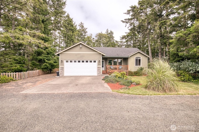566 Duck Lake Dr SE, Ocean Shores, WA 98569 - ranch-style house with a porch, concrete driveway, an attached garage, stone siding, and view of wooded area