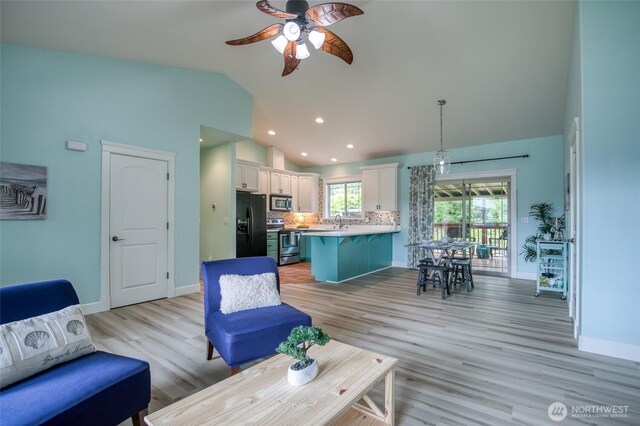 566 Duck Lake Dr SE, Ocean Shores, WA 98569 - living area with lofted ceiling, a ceiling fan, light wood-style flooring, baseboards, and recessed lighting