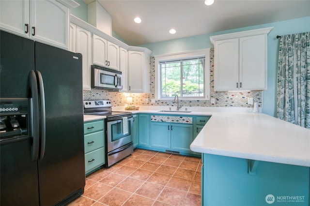 566 Duck Lake Dr SE, Ocean Shores, WA 98569 - kitchen featuring appliances with stainless steel finishes, a sink, a peninsula, tasteful backsplash, and recessed lighting