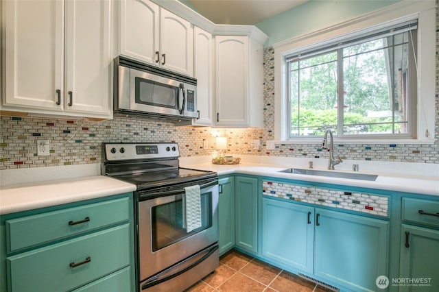 566 Duck Lake Dr SE, Ocean Shores, WA 98569 - kitchen featuring appliances with stainless steel finishes, a sink, backsplash, white cabinetry, and light countertops