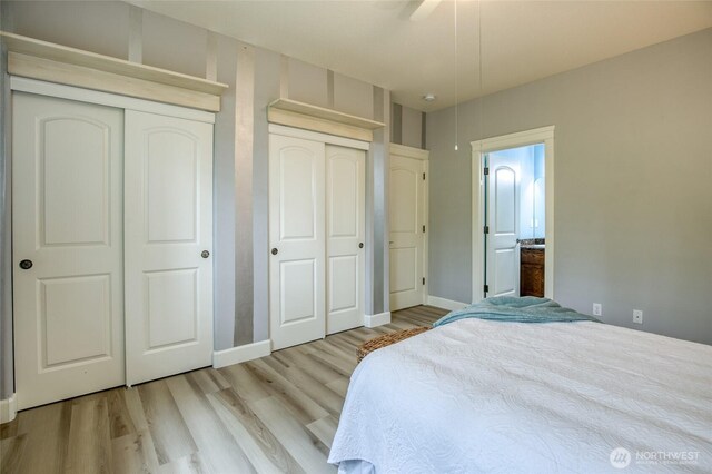 566 Duck Lake Dr SE, Ocean Shores, WA 98569 - bedroom with multiple closets, light wood-type flooring, baseboards, and ceiling fan