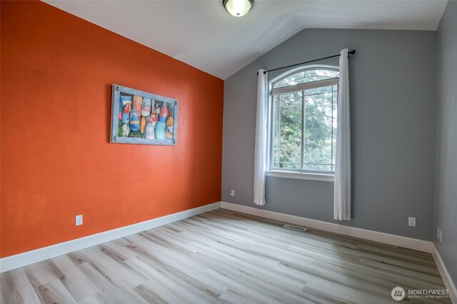 566 Duck Lake Dr SE, Ocean Shores, WA 98569 - spare room with wood finished floors, vaulted ceiling, and baseboards