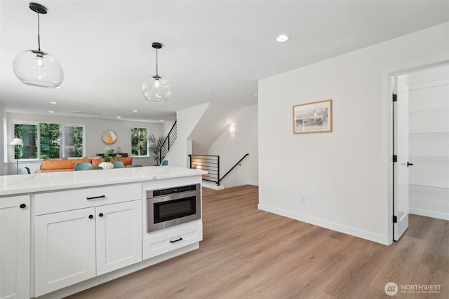 20313B 14th Ave NE, Shoreline, WA 98155 - kitchen featuring light wood-type flooring, pendant lighting, white cabinetry, recessed lighting, and baseboards
