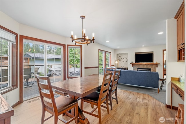 12606 Icicle Ln, Leavenworth, WA 98826 - dining space featuring a fireplace, light wood-style flooring, a chandelier, plenty of natural light, and recessed lighting