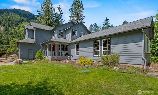 12606 Icicle Ln, Leavenworth, WA 98826 - view of front facade with a front yard, a shingled roof, covered porch, and a mountain view