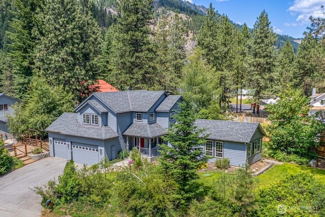 12606 Icicle Ln, Leavenworth, WA 98826 - view of front of property featuring asphalt driveway, a forest view, covered porch, and a shingled roof