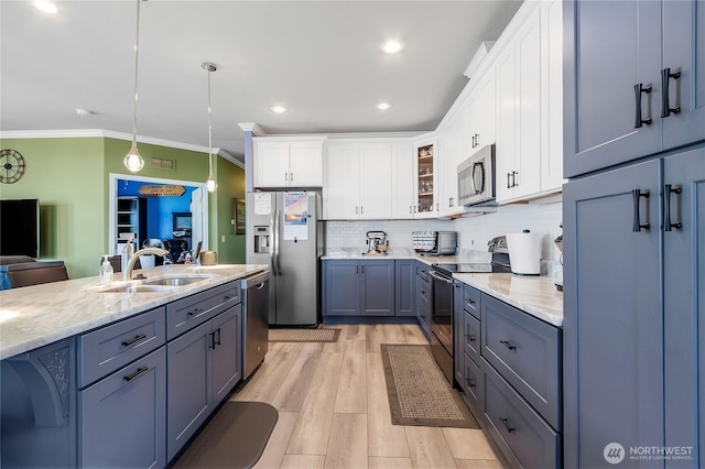 936 Mountain Villa Dr, Enumclaw, WA 98022 - kitchen featuring appliances with stainless steel finishes, a sink, ornamental molding, tasteful backsplash, and glass insert cabinets
