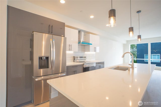 12215 Des Moines Memorial Dr S Unit A, Burien, WA 98168 - kitchen with stainless steel appliances, wall chimney range hood, light countertops, a kitchen island with sink, and backsplash
