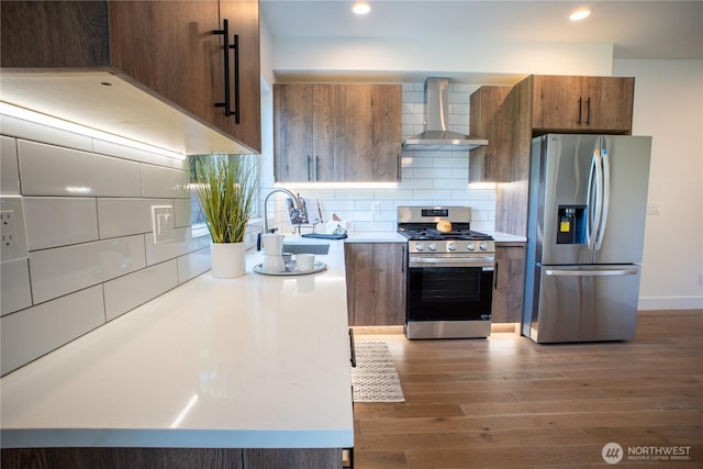 12215 Des Moines Memorial Dr S Unit A, Burien, WA 98168 - kitchen with stainless steel appliances, wall chimney exhaust hood, dark wood-style flooring, light countertops, and decorative backsplash