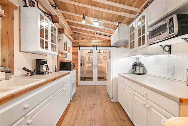 1190 Exit Rd, Maple Falls, WA 98266 - kitchen featuring wooden ceiling, black microwave, light wood-type flooring, tasteful backsplash, and white cabinetry
