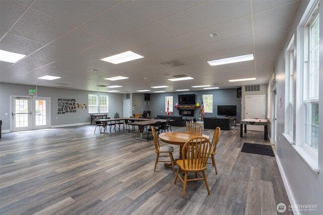 1190 Exit Rd, Maple Falls, WA 98266 - dining room featuring a paneled ceiling, wood finished floors, plenty of natural light, a fireplace, and french doors