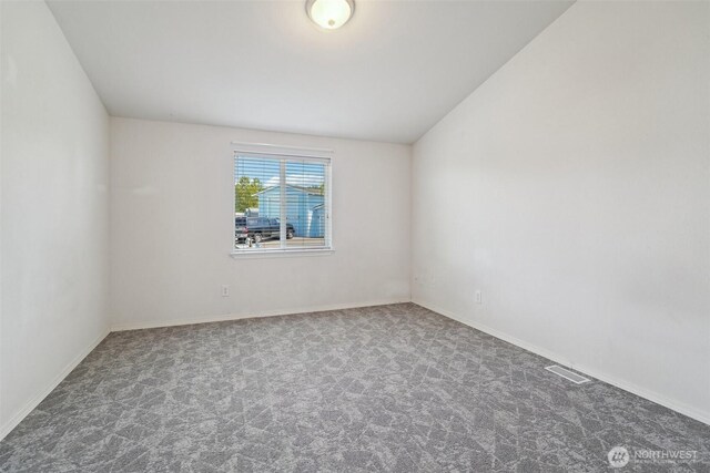 302 Oak St SW, Orting, WA 98360 - carpeted spare room with vaulted ceiling and baseboards