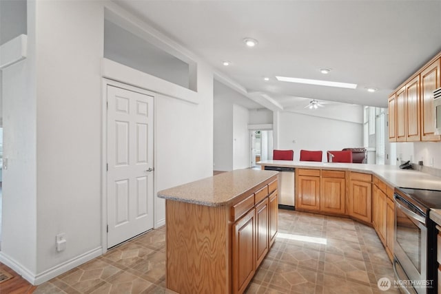 302 Oak St SW, Orting, WA 98360 - kitchen featuring appliances with stainless steel finishes, a peninsula, a skylight, recessed lighting, and a ceiling fan