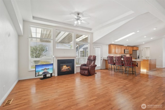 302 Oak St SW, Orting, WA 98360 - living room featuring light wood-type flooring, plenty of natural light, and a tray ceiling