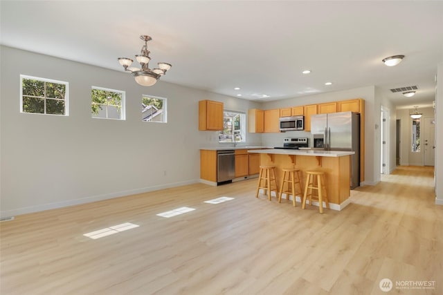 3147 6th Ave NW, Olympia, WA 98502 - kitchen featuring stainless steel appliances, baseboards, light countertops, a kitchen bar, and recessed lighting
