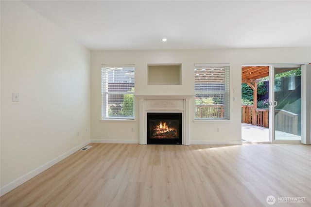 3147 6th Ave NW, Olympia, WA 98502 - unfurnished living room with wood finished floors, a glass covered fireplace, baseboards, and recessed lighting