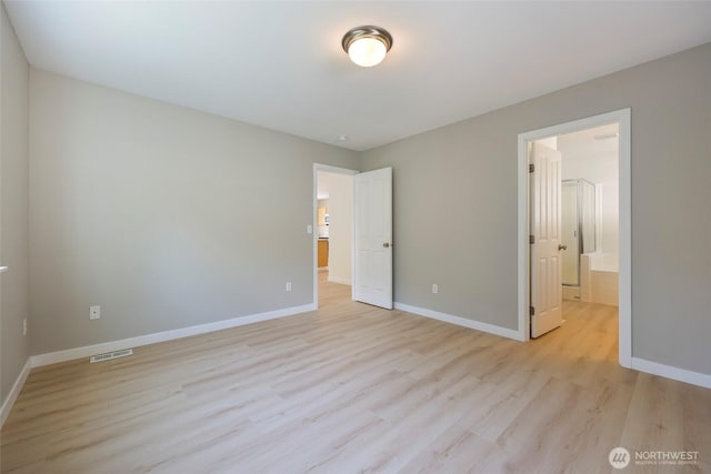 3147 6th Ave NW, Olympia, WA 98502 - unfurnished bedroom featuring light wood finished floors, baseboards, and ensuite bathroom